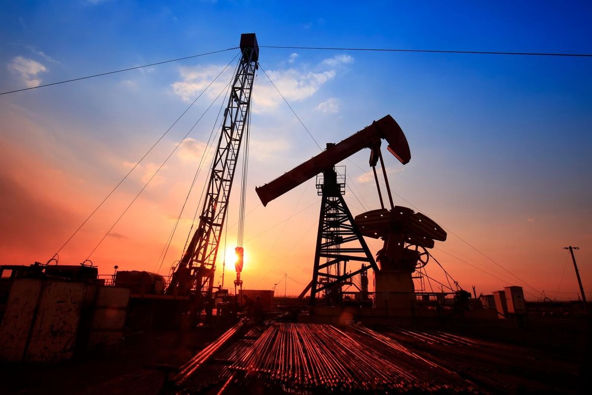 Pump jack operating at dusk in an oil field